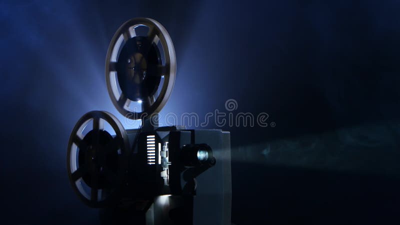 Smoky dark studio. Film rotates reels and vintage movie shows