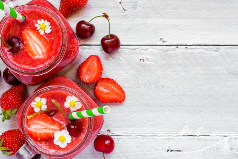 Smoothie de fraise et de cerise dans le pot en verre avec une paille et fruits frais et baies photo libre de droits Smoothie de fraise et de cerise dans le pot en verre avec une paille et fruits frais et baies photo libre de droits