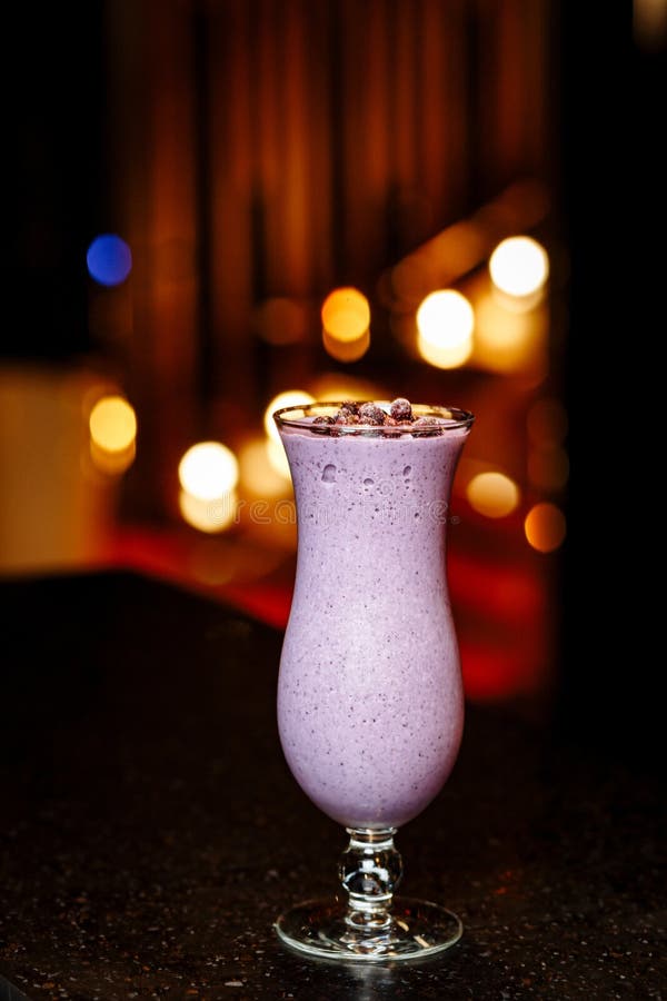 Smoothie de la baya con las bayas congeladas en una tabla negra fotografía de archivo libre de regalías Smoothie de la baya con las bayas congeladas en una tabla negra fotografía de archivo libre de regalías