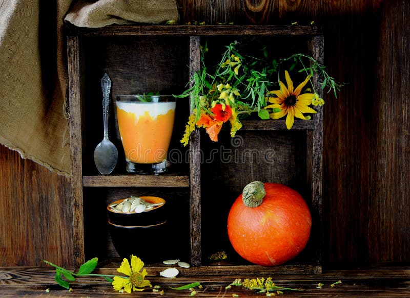 Smoothie de la calabaza con un ramo de wildflowers fotografía de archivo Smoothie de la calabaza con un ramo de wildflowers fotografía de archivo