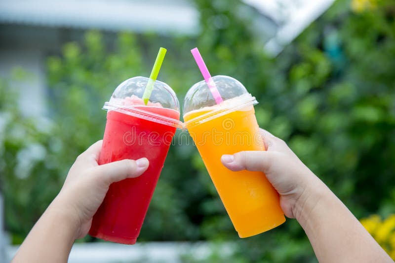 Smoothie de la fruta Mano que sostiene la taza pl?stica de smoothie colorido de la fruta en el caf? lindo Mano que sostiene la ta fotos de archivo libres de regalías Smoothie de la fruta Mano que sostiene la taza pl?stica de smoothie colorido de la fruta en el caf? lindo Mano que sostiene la ta fotos de archivo libres de regalías