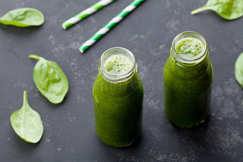 Smoothie verde de la espinaca en el tarro de cristal en la tabla del negro oscuro, comida del detox para el desayuno imagenes de archivo Smoothie verde de la espinaca en el tarro de cristal en la tabla del negro oscuro, comida del detox para el desayuno imagenes de archivo