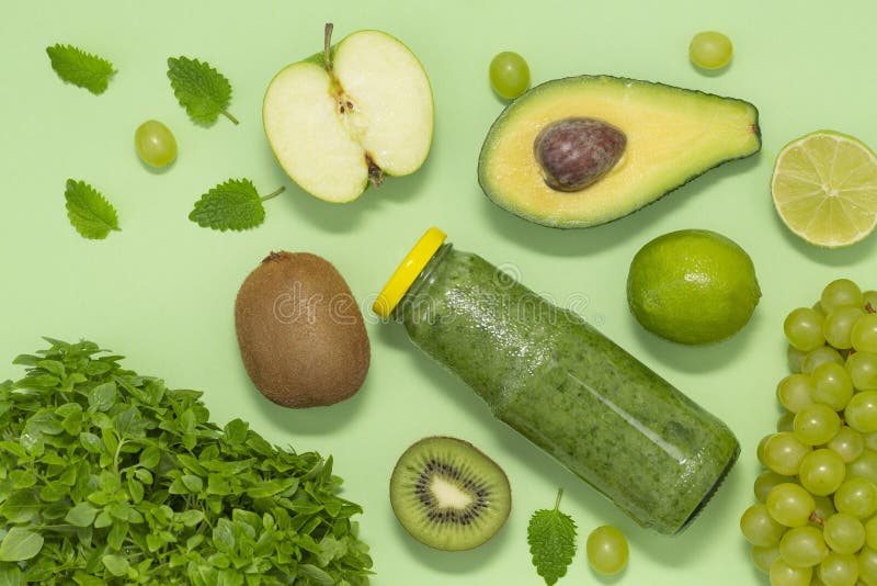 Smoothie vert coloré dans la bouteille sur le fond vert, vue supérieure Nourriture saine pour le petit déjeuner et le casse-croûte