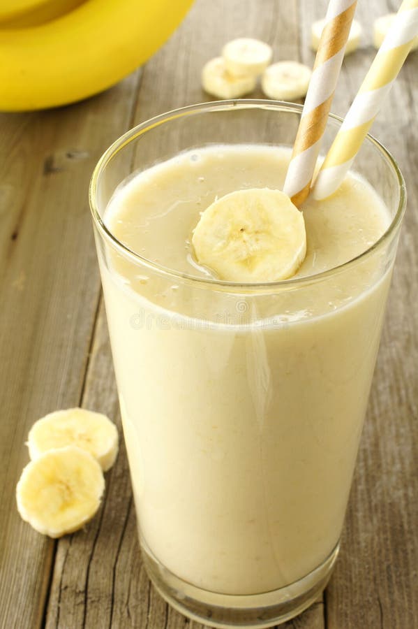 Smoothie банана в стекле на древесине стоковые фото Smoothie банана в стекле на древесине стоковые фото