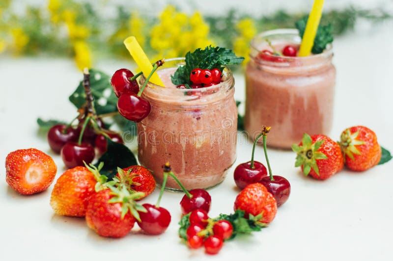 Smoothie банана и клубники 2 холодных Smoothies банана клубники в стеклах с ингридиентами на кухонном столе Клубника Bana стоковые фотографии rf Smoothie банана и клубники 2 холодных Smoothies банана клубники в стеклах с ингридиентами на кухонном столе Клубника Bana стоковые фотографии rf