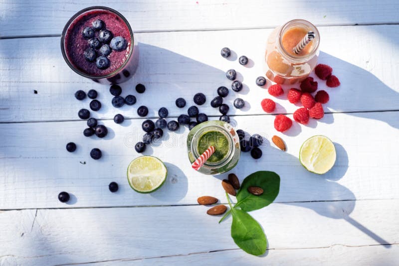 Smoothie голубики, spinachy и оранжевых на деревянной белой предпосылке в природе Стекла smoothie с ягодой и мятой Ягода, le стоковая фотография Smoothie голубики, spinachy и оранжевых на деревянной белой предпосылке в природе Стекла smoothie с ягодой и мятой Ягода, le стоковая фотография