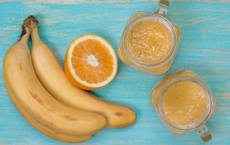 Smoothies con la naranja y el plátano (visión superior, foco selectivo) imagenes de archivo Smoothies con la naranja y el plátano (visión superior, foco selectivo) imagenes de archivo