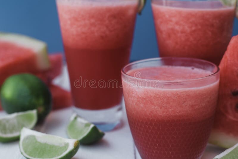 Smoothies de la pastèque fraîche, chaux avec de la glace sur le fond bleu images libres de droits Smoothies de la pastèque fraîche, chaux avec de la glace sur le fond bleu images libres de droits