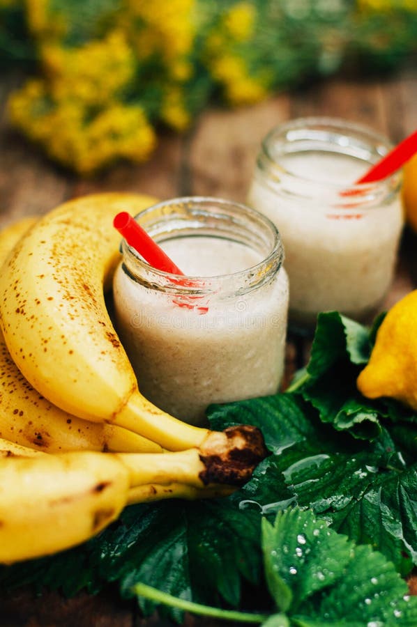 smoothies owocowe Bananowi smoothies z mlekiem Bananowy Smoothie na drewnianym stole Zdrowy śniadanie: bananowy smoothie z oatmea zdjęcie stock smoothies owocowe Bananowi smoothies z mlekiem Bananowy Smoothie na drewnianym stole Zdrowy śniadanie: bananowy smoothie z oatmea zdjęcie stock