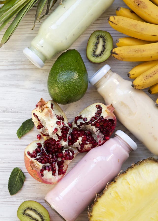 Smoothies плода или milkshake различных цветов в стеклянных опарниках с красочными плодами на белой деревянной предпосылке, взгля стоковая фотография Smoothies плода или milkshake различных цветов в стеклянных опарниках с красочными плодами на белой деревянной предпосылке, взгля стоковая фотография