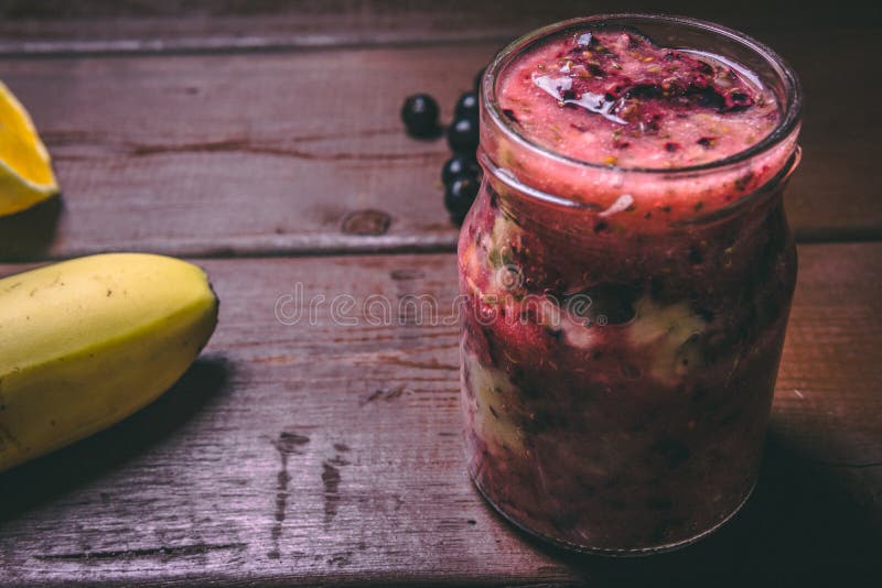 Smoothies плода сделали со свежими ингредиентами на деревянной предпосылке Черная смородина, апельсин и банан E стоковые изображения Smoothies плода сделали со свежими ингредиентами на деревянной предпосылке Черная смородина, апельсин и банан E стоковые изображения