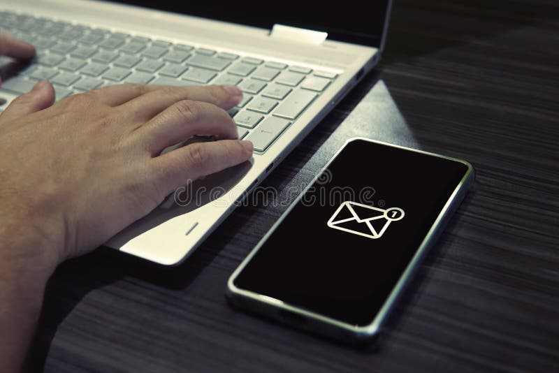 SMS lösenord för nätverkstillträde på telefonen, medan skriva på bärbara datorn Generisk symbol av post på denavskärmade smartpho royaltyfri fotografi SMS lösenord för nätverkstillträde på telefonen, medan skriva på bärbara datorn Generisk symbol av post på denavskärmade smartpho royaltyfri fotografi