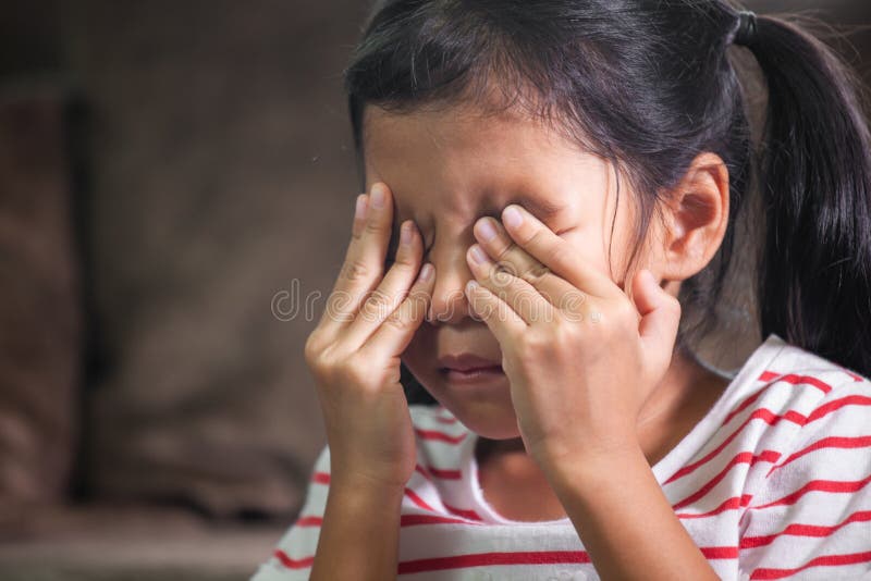 Sad asian child girl is crying and rubbing her eyes with her hands. Sad asian child girl is crying and rubbing her eyes with her hands