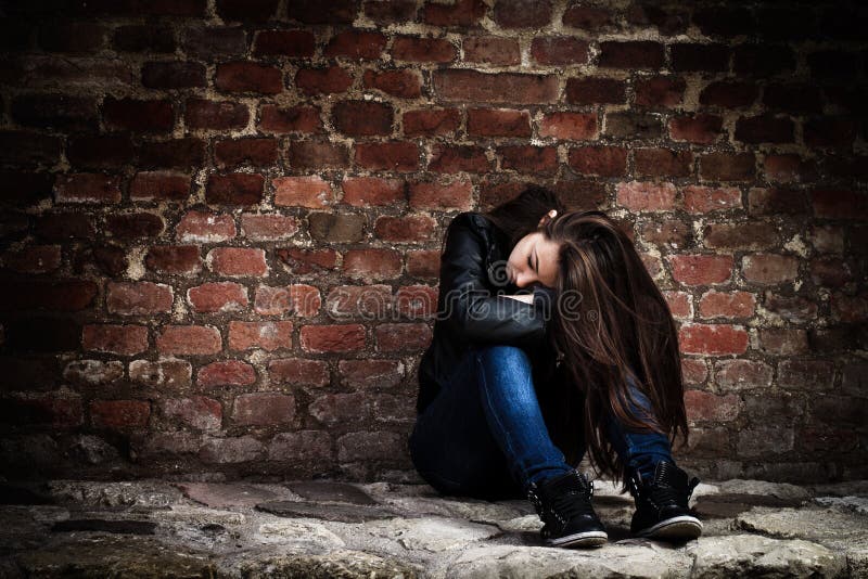 Sad teenage girl, leaning on an old brick wall. Sad teenage girl, leaning on an old brick wall.