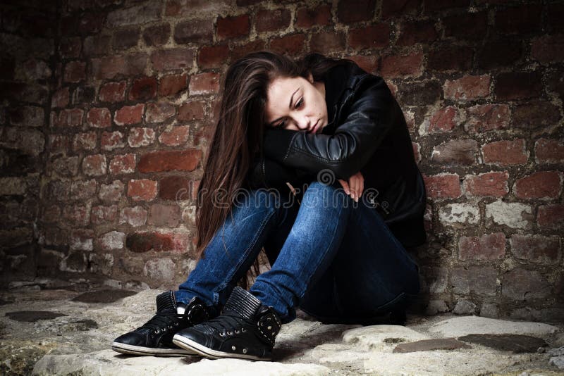 Sad teenage girl, leaning on an old brick wall. Sad teenage girl, leaning on an old brick wall.