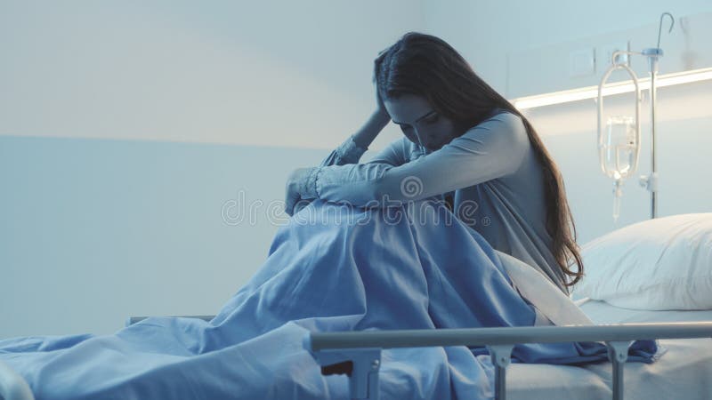 Sad female patient lying in the hospital bed at night, she is sleepless, lonely and worried. Sad female patient lying in the hospital bed at night, she is sleepless, lonely and worried