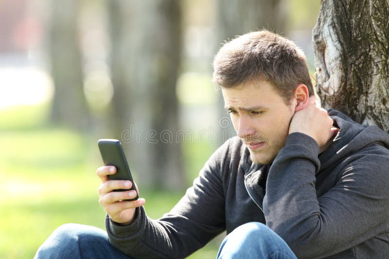 Smutne nastoletnie czytelnicze telefon wiadomości zdjęcie stock Smutne nastoletnie czytelnicze telefon wiadomości zdjęcie stock