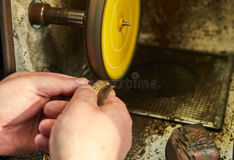 Smyckenproduktion Juveleraren polerar ett guld- armband arkivfoton Smyckenproduktion Juveleraren polerar ett guld- armband arkivfoton