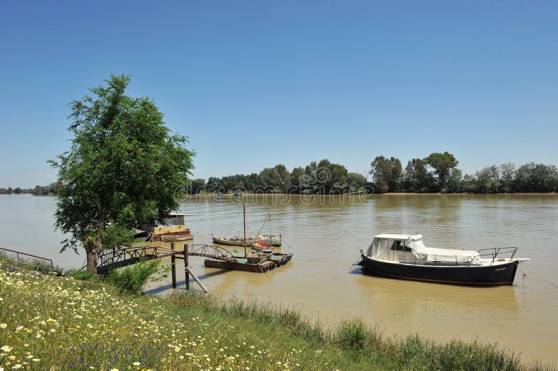 Små fartyg på pir, den Guadalquivir floden, som den passerar till och med Coria del Rio de Janeiro, det Seville landskapet, Andal arkivfoto Små fartyg på pir, den Guadalquivir floden, som den passerar till och med Coria del Rio de Janeiro, det Seville landskapet, Andal arkivfoto