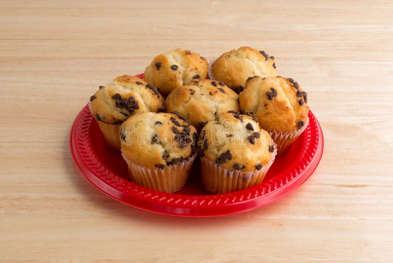 Små muffin för chokladchip på en röd platta royaltyfria foton Små muffin för chokladchip på en röd platta royaltyfria foton