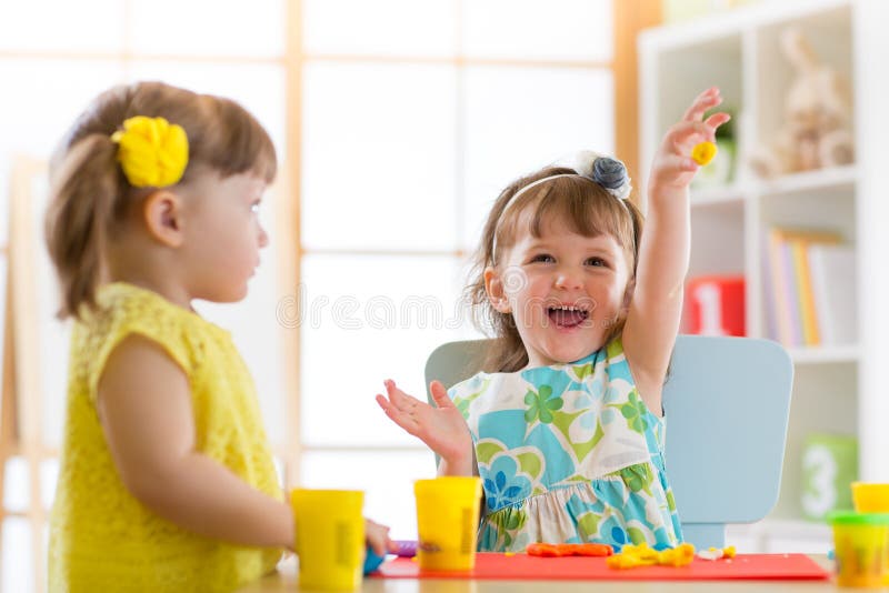 Små ungar som har gyckel samman med färgrik modellera lera på daycare Idérika ungar som hemma gjuter Barnflickalek med pl royaltyfria bilder Små ungar som har gyckel samman med färgrik modellera lera på daycare Idérika ungar som hemma gjuter Barnflickalek med pl royaltyfria bilder
