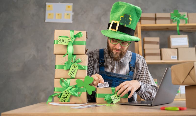 Småföretag. Arbetarleveransservice i leprechaun som ägare av förpackningslådor arbetar med kontrollorder till arkivbilder