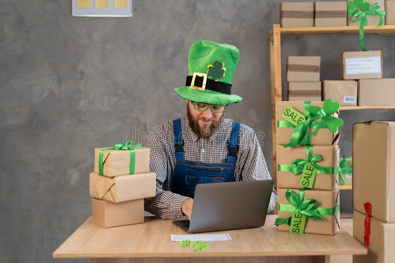 Småföretag som vill ha företagaren leprechaun är frilance och arbetar på hemmakontoret med dator online royaltyfri fotografi