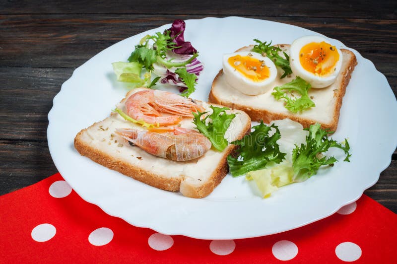 Smörgåsar med räka, ägg, basilika, sallad, bröd på wood bakgrund Läckra kalla mellanmål vegetariska mål äta som är sunt royaltyfri foto Smörgåsar med räka, ägg, basilika, sallad, bröd på wood bakgrund Läckra kalla mellanmål vegetariska mål äta som är sunt royaltyfri foto