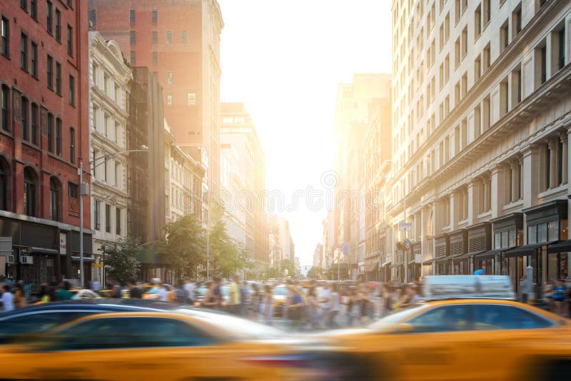 Snabb-stegat liv i New York City gataplats med taxiar som kör ner den 5th avenyn och folkmassor av folk i New York City royaltyfri foto Snabb-stegat liv i New York City gataplats med taxiar som kör ner den 5th avenyn och folkmassor av folk i New York City royaltyfri foto