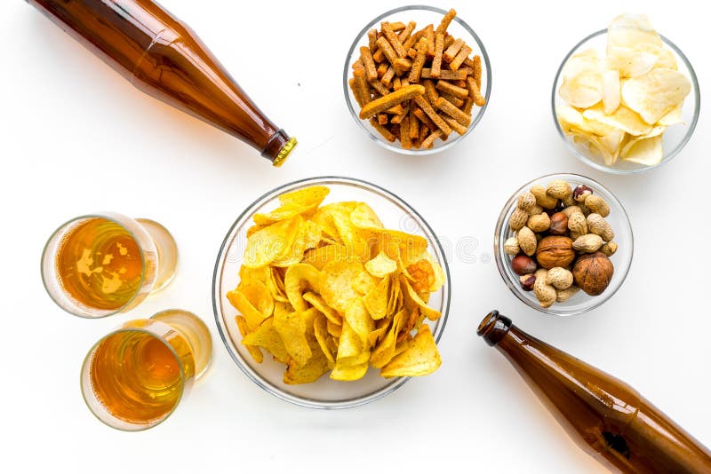 Snacks and Beer. Chips, Nuts, Rusks Near Beer on White Background Top