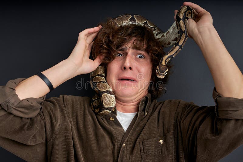 the snake climbed on male head, man is even more afraid, he feels danger