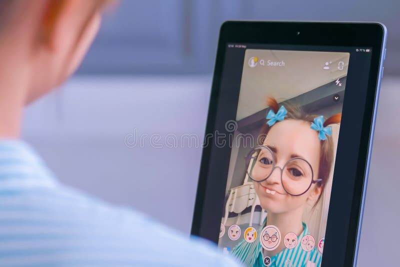 Snapchat multimedia messager with 3d face mask filter on tablet