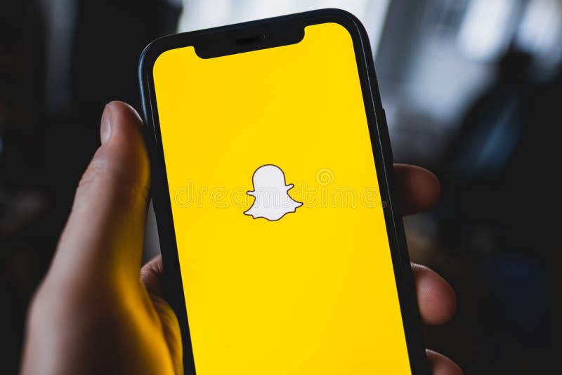 Snapchat app logo on the smartphone screen in hand.