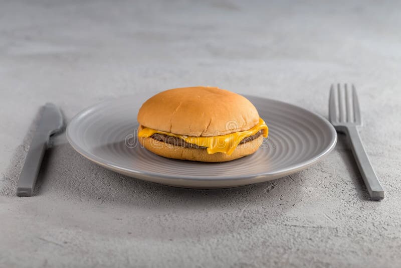 Snel voedsel met heerlijke cheeseburger op een ceramische plaat stock foto's Snel voedsel met heerlijke cheeseburger op een ceramische plaat stock foto's