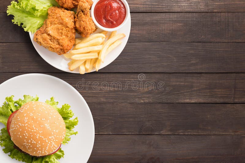 Snel voedselreeks gebraden kip, frieten en hamburger op houten stock afbeeldingen Snel voedselreeks gebraden kip, frieten en hamburger op houten stock afbeeldingen