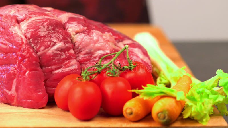Snijvlees. het kooksnijden van rauw vlees op een houten bord met een mes.
