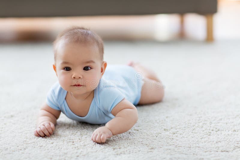 Snoepje weinig Aziatische babyjongen die op vloer liggen stock afbeelding Snoepje weinig Aziatische babyjongen die op vloer liggen stock afbeelding
