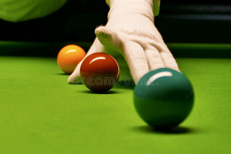 Snooker table and balls with referee arranging the balls