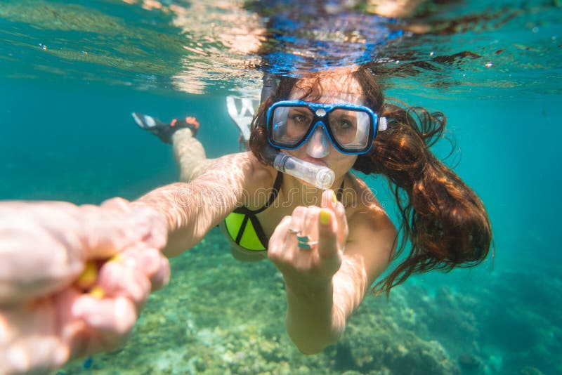 Snorkelling woman makes tempting gesture in ocean