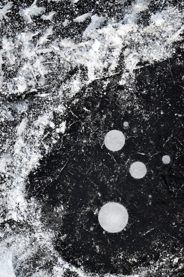 Snow and air bubbles under the ice of a frozen pond stock photos Snow and air bubbles under the ice of a frozen pond stock photos