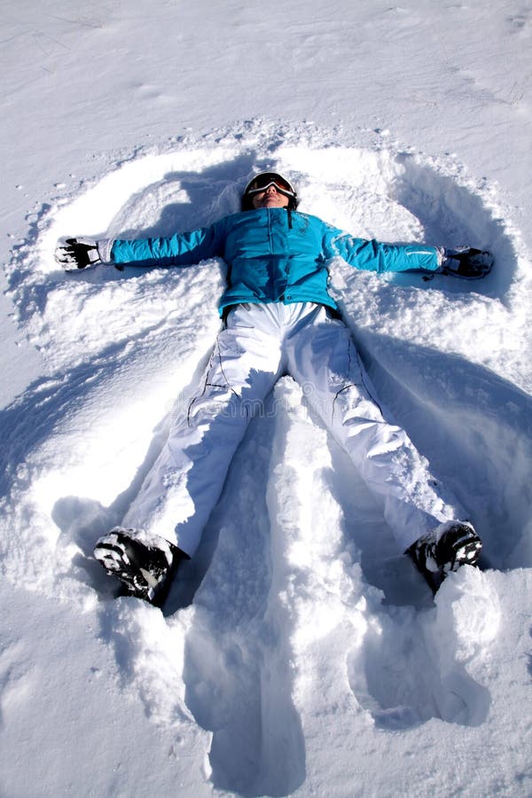 Young woman doing in the fresh snow angel