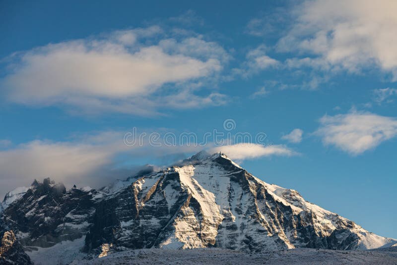 Snow covered Almirante Nieto mountain with clouds passing over the peak royalty free stock photo