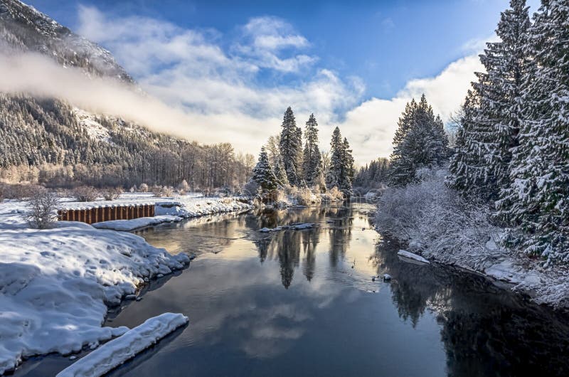 Beautiful winter river landscape in sunny frosty morning. Snow covered forest are on both sides of riverbanks. Beautiful winter river landscape in sunny frosty morning. Snow covered forest are on both sides of riverbanks