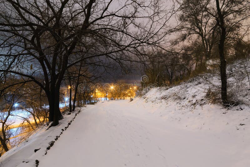 Snow covered path lit by street lights stock photo Snow covered path lit by street lights stock photo