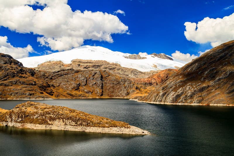 Snow covered peak and a dark lake