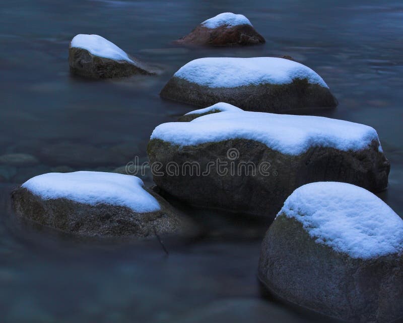 Snow covered river rocks