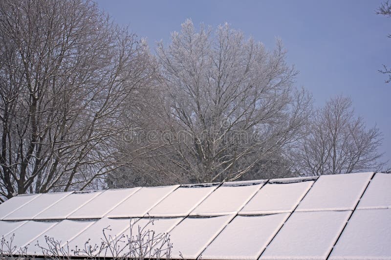 Snow covered solar panels shrouded in fog and a heavy hoarfrost.