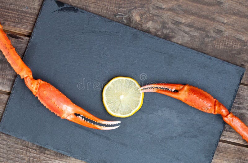 Snow crab claw with lemon on a table. Selective focus