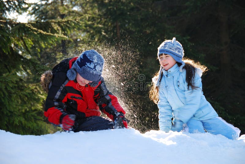 Dos, hermano a hermana, divirtiéndose en la nieve, lanzamiento bolas de nieve sobre el cada próximo.