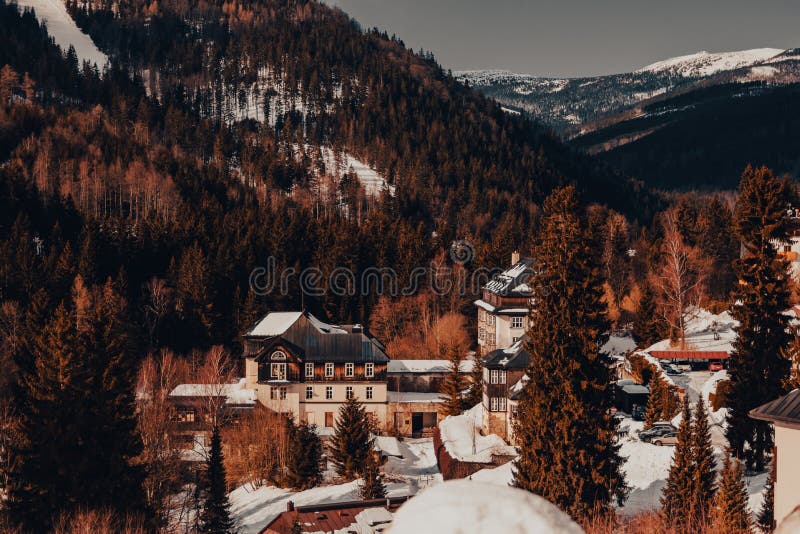 Snow mountain village, winter pine forest at sunset royalty free stock photo